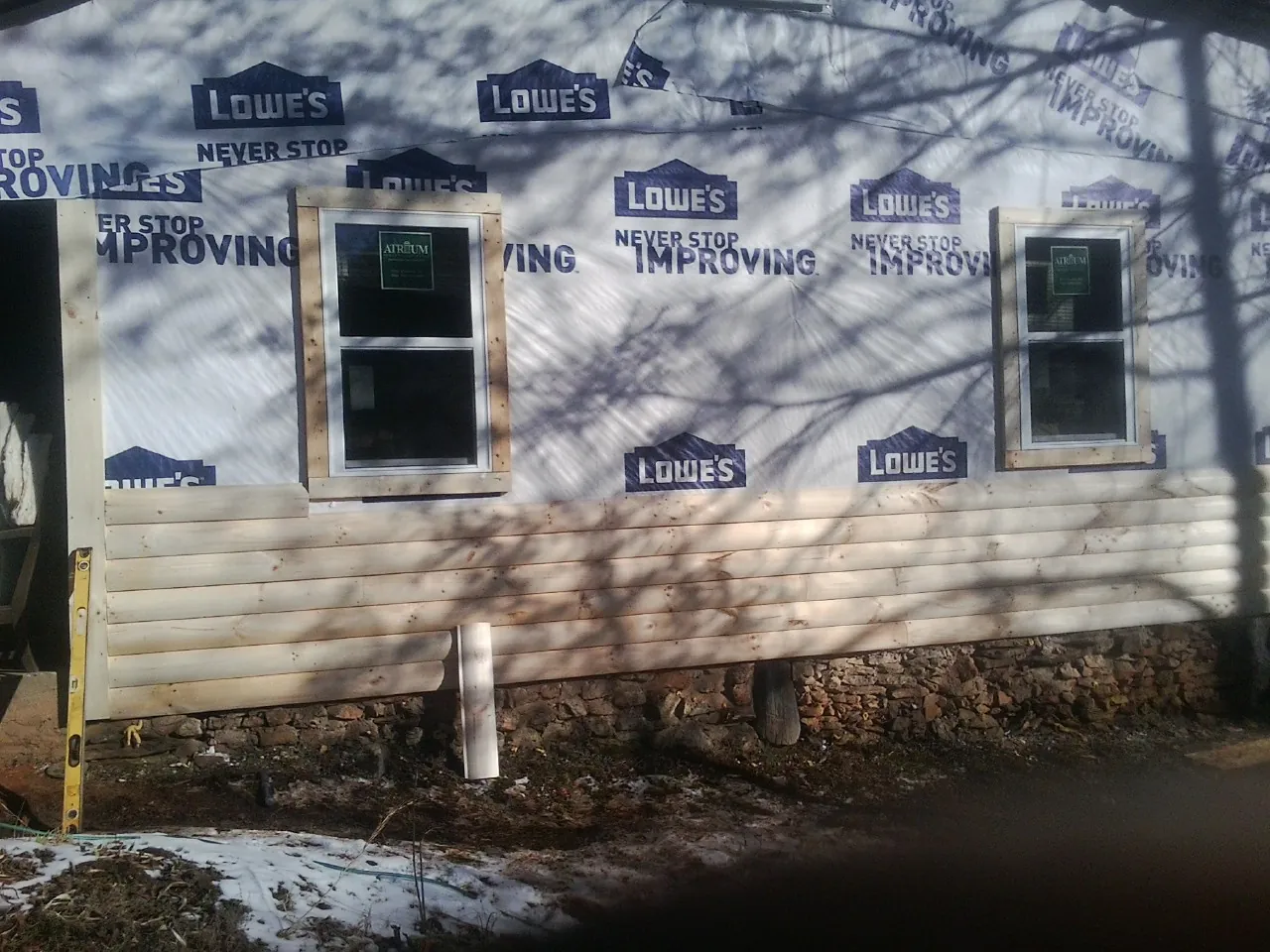 House wrap and new log siding going up on an exterior wall in Williamstown